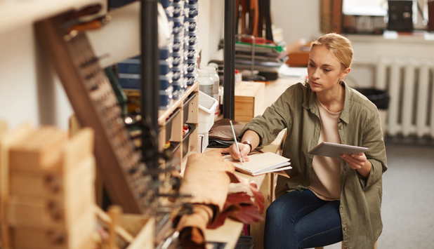 Small business owner reviewing production notes in her workshop